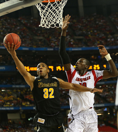 Tekele Cotton #32 of the Wichita State Shockers puts the ball up to the basket against Gorgui Dieng #10 of the Louisville Cardinals.