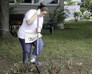 Rebecca Smith plants a tree at the annual Block Blitz on Friday, where volunteers completed tasks on houses in North Syracuse.