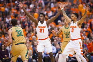 Tyler Roberson (21) and Michael Gbinije (0) defend against Notre Dame's Steve Vasturia on Thursday night. The Orange suffocated Notre Dame in the 81-66 win.