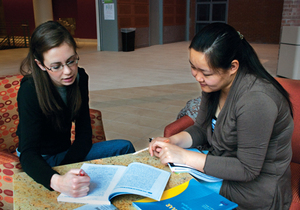 Megan Brimmer (left) and Lian Qiao, a senior international relations major and a music performance teaching assistant, respectively, practice conventional English skills as part of the Conversation Partner program, which helps international TAs establish their English vocabulary.