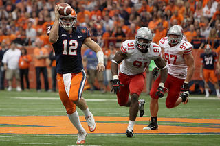 Ryan Nassib pump fakes as he runs away from Stony Brook defenders.