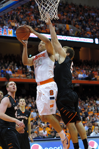 Brandon Triche leans around Princeton guard T.J. Bray to attempt a layup.