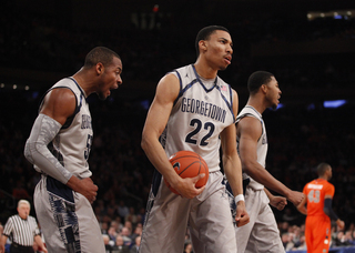 (Left) Georgetown's Jabril Trawick (#55) and Otto Porter (#22) walk out of the paint after defending against Syracuse.