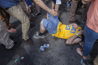 A party goer is helped up after falling to the ground, Friday afternoon at Castle's Court.