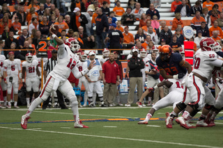 Wolfpack quarterback Jacoby Brissett unleashes a throw as SU defensive end Micah Robinson can't overcome his blocker.