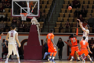 VT's Satchel Pierce releases a midrange jumper over the outstretched right arm of Christmas.