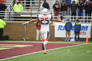 Whitner holds his arms out wide while running across the field.