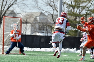 St. John's Joe Madsen fires off a shot toward SU goalie Evan Molloy. 