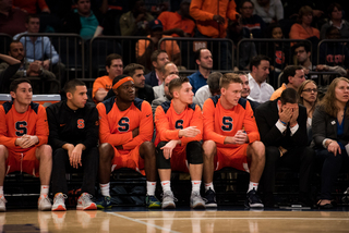 Syracuse's bench looks on.