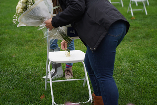 Madeline Messare sets a white rose onto seat 52J, where Gretchen Joyce Dater sat on Pan Am Flight 103.